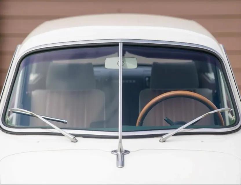 A close-up shot of a Horch 853 with a replaced windshield. The windshield is clear and new, seamlessly integrated with the car's design. Focus on the details of the replacement and the car's elegant lines.